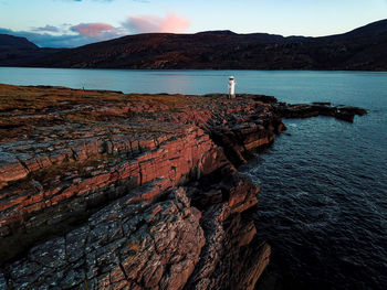 Rock formations by sea against sky