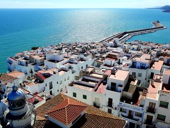 High angle view of cityscape by sea against clear sky