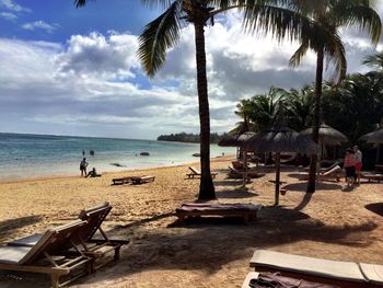 Scenic view of beach against cloudy sky