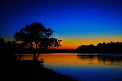 Scenic view of lake against clear sky at sunset