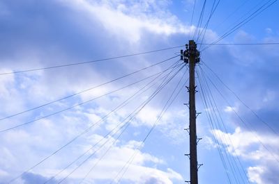 Low angle view of electricity pylon against sky