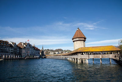 Bridge over river amidst buildings against sky