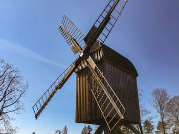 Low angle view of traditional windmill against sky