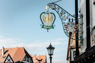 Low angle view of a restaurant sign against sky