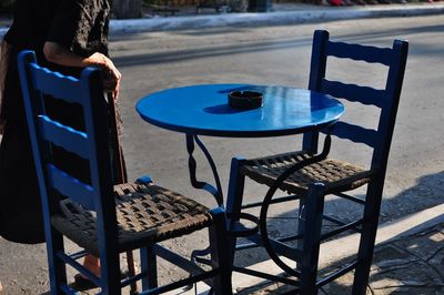 Low section of senior woman walking by sidewalk cafe