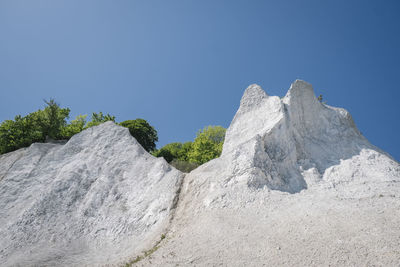 Low angle view of rocks against blue sky