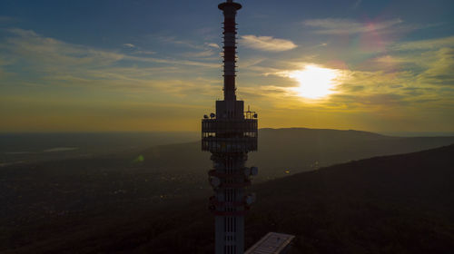 View of tower and building against sky during sunset