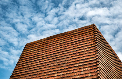Abstract background of red roof tile on cloudy blue sky