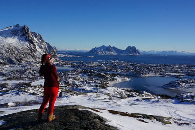 Full length of woman standing on snow covered mountain