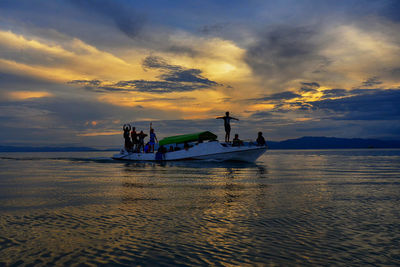 Silhouette of people on boat during sunset