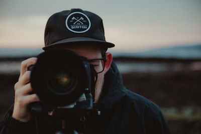 Midsection of man photographing camera