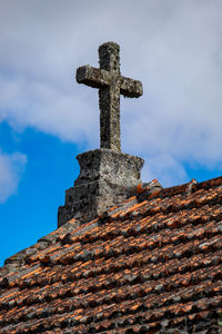 Low angle view of cross on temple against sky