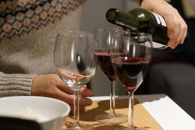 Midsection of wine glasses on table