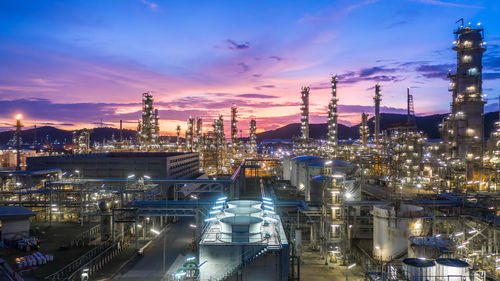 Aerial view oil and gas tank with oil refinery background at night, glitter lighting petrochemical.