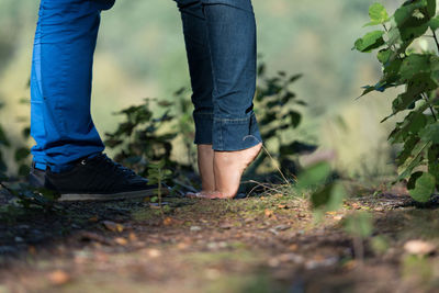 Low section of couple standing amidst plants