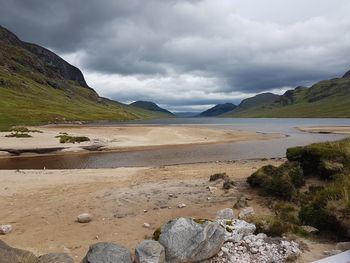 Scenic view of land and mountains against sky