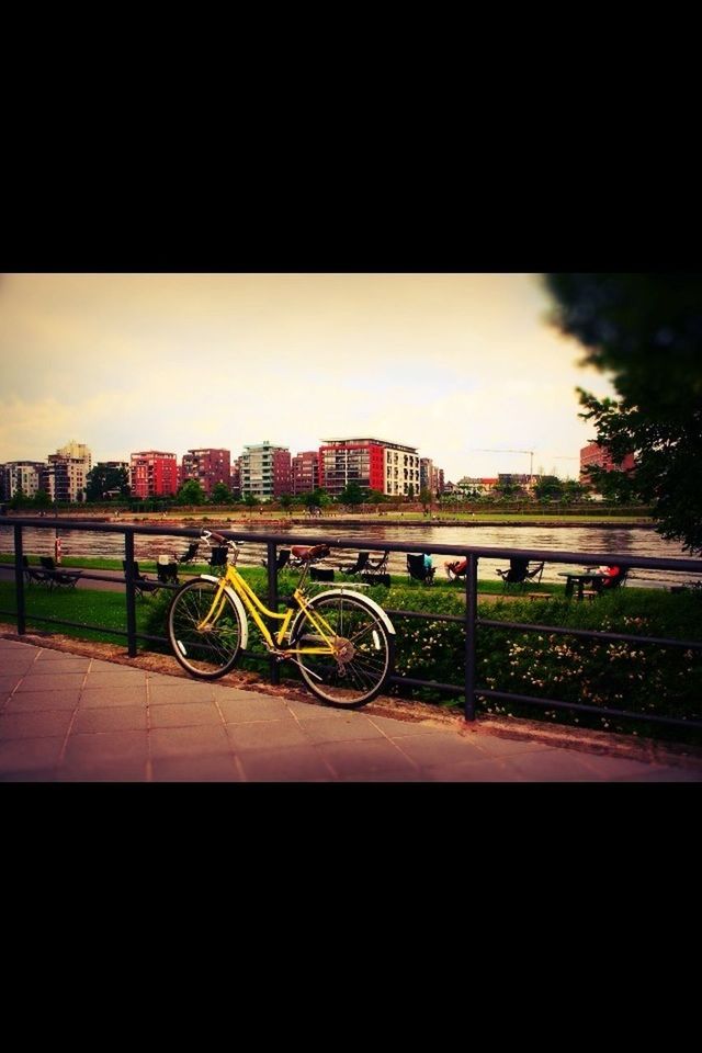 bicycle, transportation, land vehicle, mode of transport, sky, built structure, architecture, street, building exterior, road, city, car, stationary, parking, parked, outdoors, on the move, copy space, cloud - sky