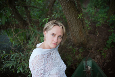 Portrait of smiling young woman standing in forest