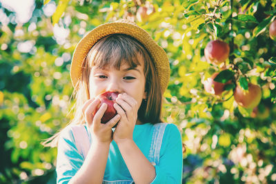 Girl eating fresh apple in farm