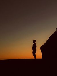 Silhouette man standing against clear sky during sunset