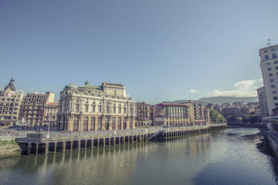 Buildings in city against clear sky