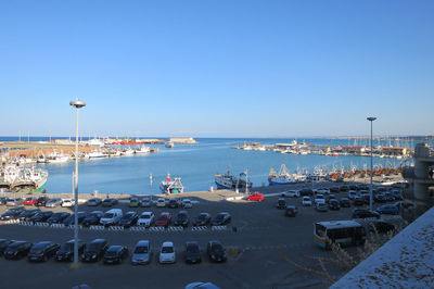 High angle view of harbor by sea against blue sky