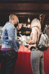 Couple buying coffee from food cart in city