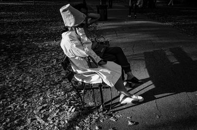 High angle view of person sitting on footpath