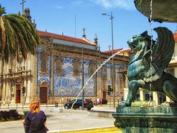 Fountain in city against clear sky