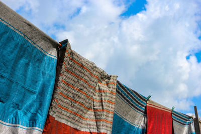 Low angle view of clothes drying against blue sky