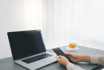 Midsection of man using laptop on table