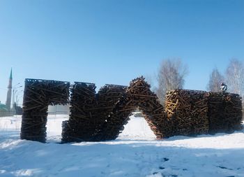 Snow covered field against clear blue sky