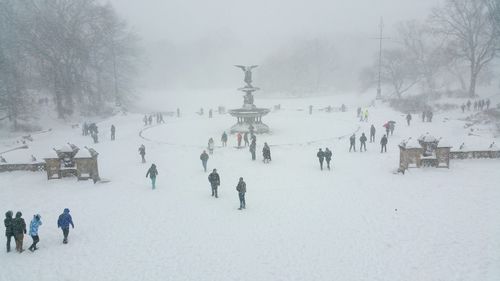 People sitting on snow covered landscape