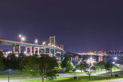 Illuminated city against clear sky at night