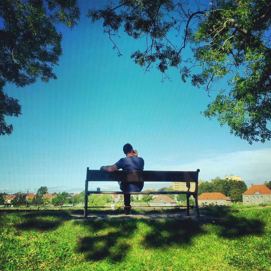 lifestyles, leisure activity, full length, grass, clear sky, casual clothing, rear view, sitting, tree, bench, relaxation, childhood, park - man made space, person, men, elementary age, boys