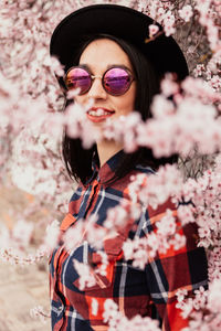 Portrait of woman standing amidst cherry tree