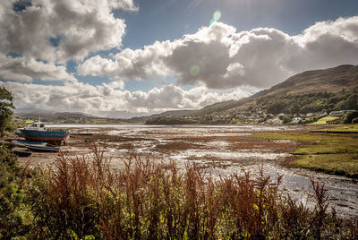 Scenic view of lake against cloudy sky