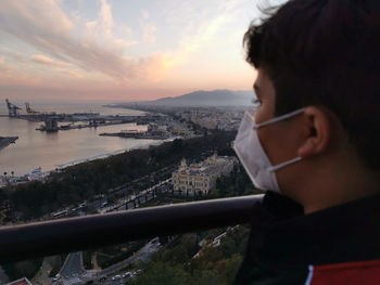 Portrait of man looking at cityscape against sky