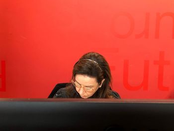 Portrait of woman working on red wall