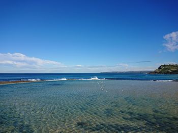 Scenic view of beach against blue sky