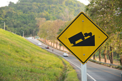 Road sign against trees