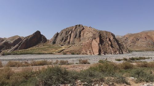 Scenic view of arid landscape against clear blue sky