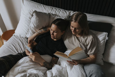 High angle view of homosexual couple relaxing in bed together