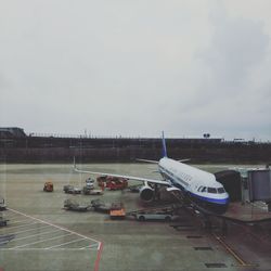Airplane on runway against sky