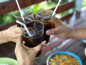 Midsection of man holding coca-cola soda for celebrate with friends 