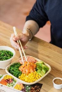 Midsection of man having food at table