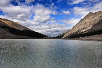 Scenic view of lake by mountains against sky