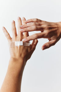 Cropped hand of woman gesturing against white background