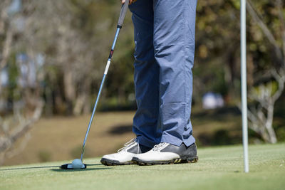 Low section of man standing on golf course