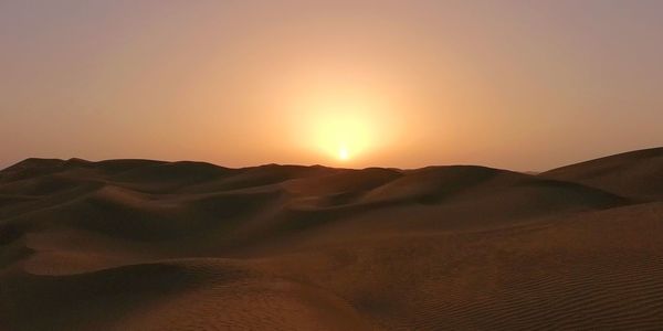 Scenic view of desert against sky during sunset